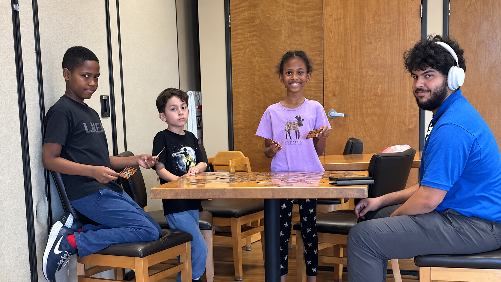 Students and a club leader working on a hands-on craft project at a table