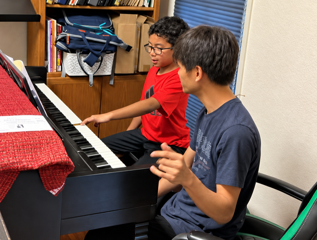Instructor guiding a student at the keyboard during a Keys to Confidence beginner piano lesson